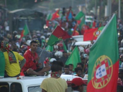 Mensen met Portugese vlaggen op auto's.