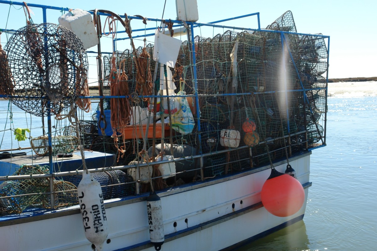 Vissersboot met een stapel vangkorven van metaal om octopus mee te vangen.