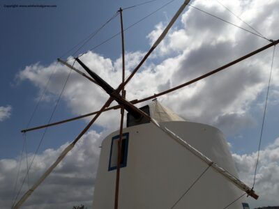 De geheel gerestaureerde windmolen Moinho do Leitão gefotografeerd tegen een blauwe wolkenhemel.