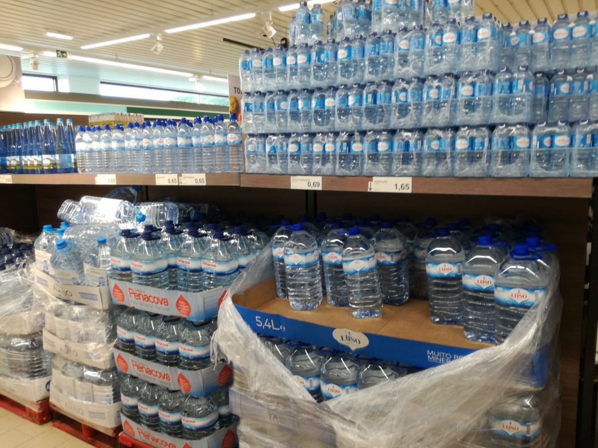 Grootverpakkingen met flessen mineraalwater van verschillende merken in de supermarkt.