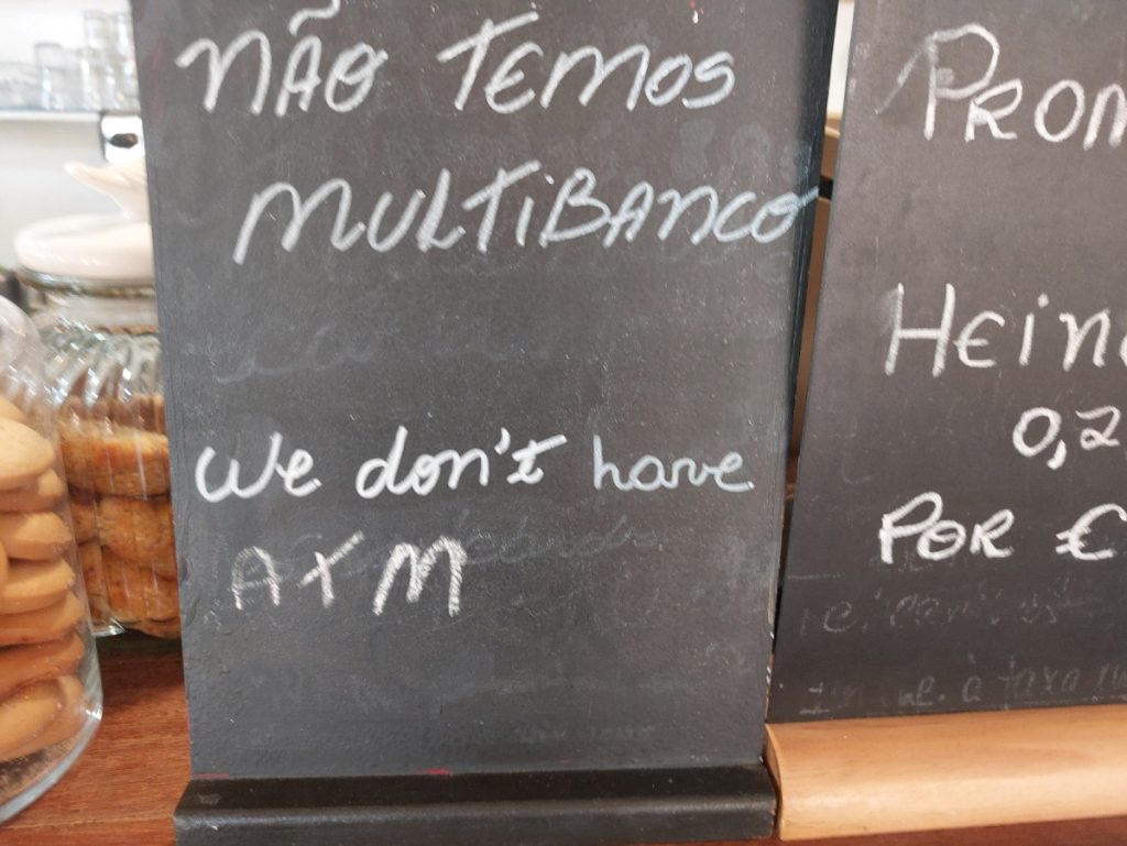 Krijtbord met erop geschreven 'não temos Multibanco' en daaronder 'we don't have ATM', in een pastelaria in Portugal