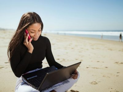 vrouw met laptop op strand