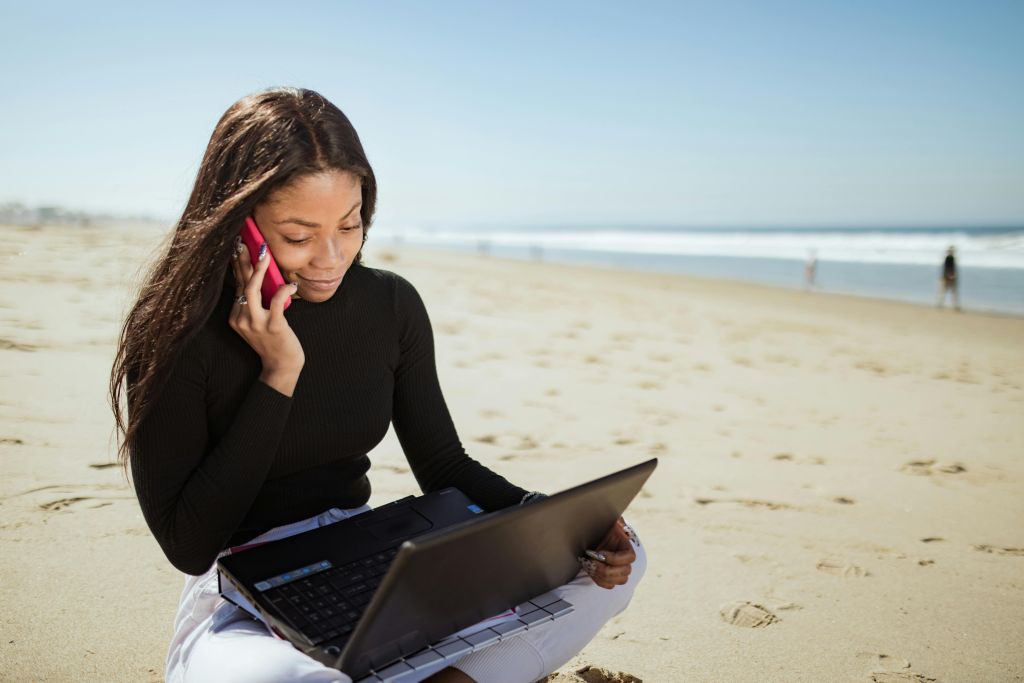 vrouw met laptop op strand